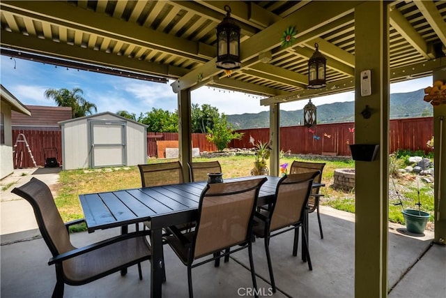 18993 Janisse Ln, Lake Elsinore, CA 92530 - view of patio / terrace with a storage shed, outdoor dining space, an outbuilding, a mountain view, and a ceiling fan
