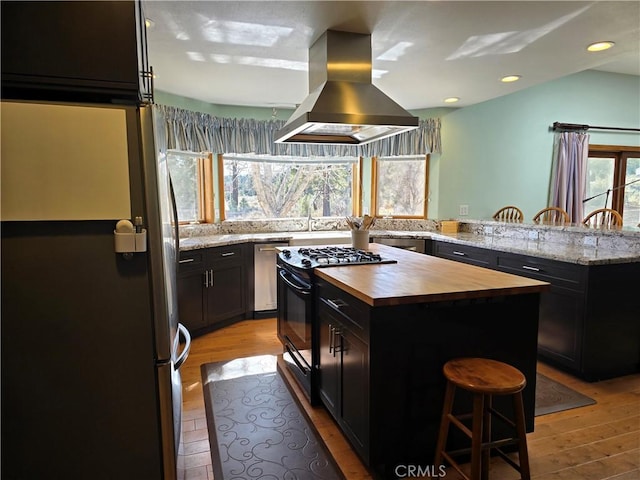 1014 Dusty Rd, Frazier Park, CA 93225 - kitchen with wood counters, stainless steel appliances, island range hood, a breakfast bar area, and recessed lighting