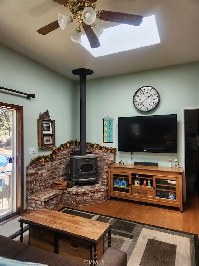 1014 Dusty Rd, Frazier Park, CA 93225 - living area featuring a wood stove, wood finished floors, a skylight, a ceiling fan, and vaulted ceiling