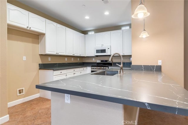 26392 Fowler Dr, Loma Linda, CA 92354 - kitchen featuring white microwave, a peninsula, white cabinetry, stainless steel range, and gas stove