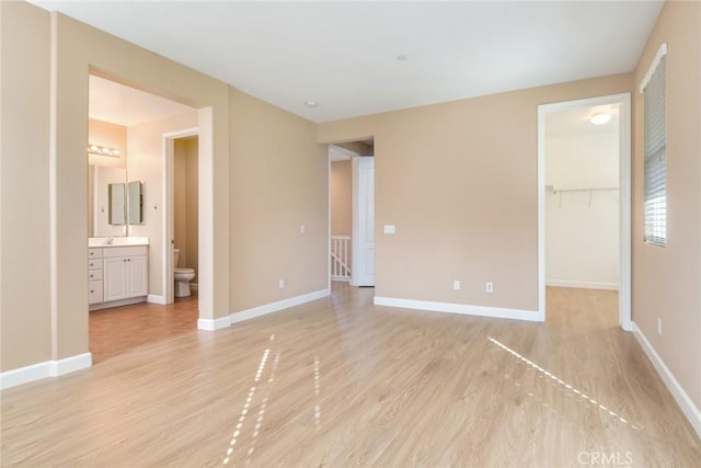 26392 Fowler Dr, Loma Linda, CA 92354 - unfurnished bedroom with light wood-style floors, a spacious closet, baseboards, ensuite bathroom, and a closet