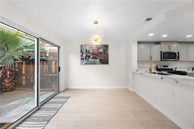 2407 Galisteo St, Corona, CA 92882 - unfurnished dining area with light wood-style floors, a chandelier, baseboards, recessed lighting, and a sink