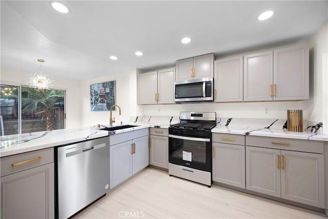 2407 Galisteo St, Corona, CA 92882 - kitchen featuring stainless steel appliances, gray cabinets, a sink, light stone counters, and recessed lighting