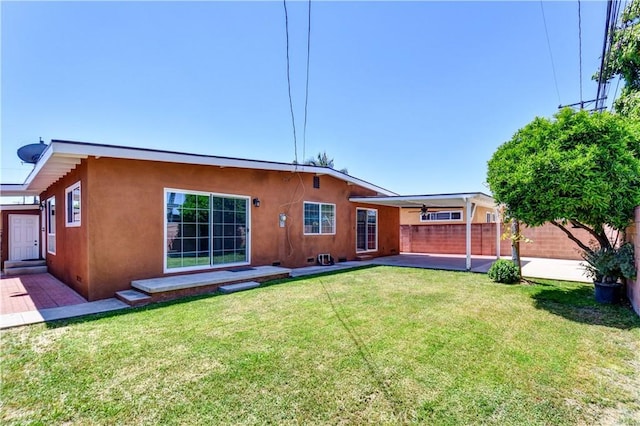 rear view of property featuring stucco siding and a patio area