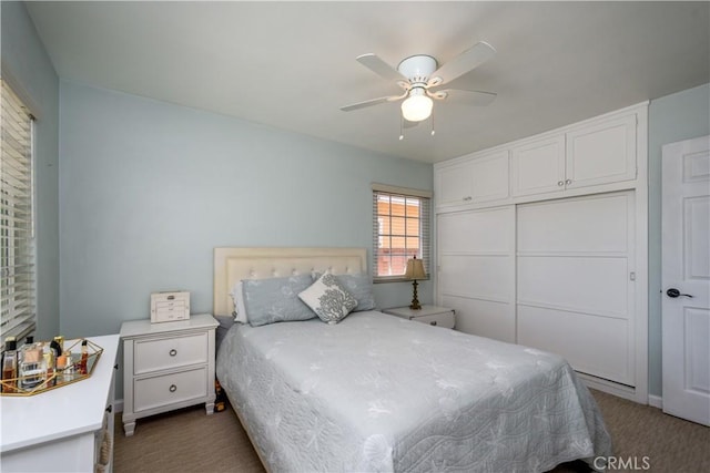 bedroom with dark carpet, a closet, and ceiling fan