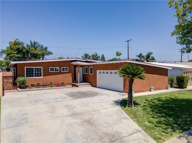 ranch-style home featuring an attached garage, stucco siding, driveway, and a front yard