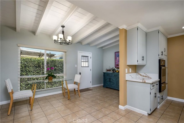 kitchen featuring oven, light countertops, a chandelier, a warming drawer, and baseboards