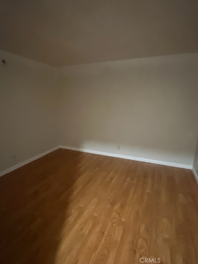 unfurnished room with baseboards and light wood-type flooring