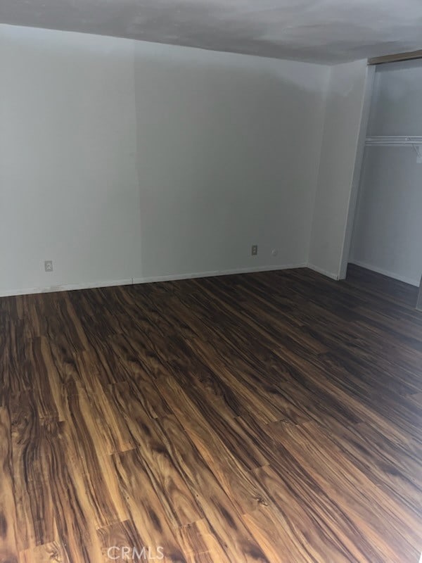 unfurnished bedroom featuring dark wood-style floors and baseboards