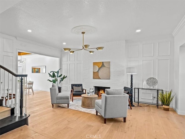 5505 Paseo Joaquin, Yorba Linda, CA 92886 - living area with stairs, a chandelier, light wood-style flooring, a fireplace, and crown molding