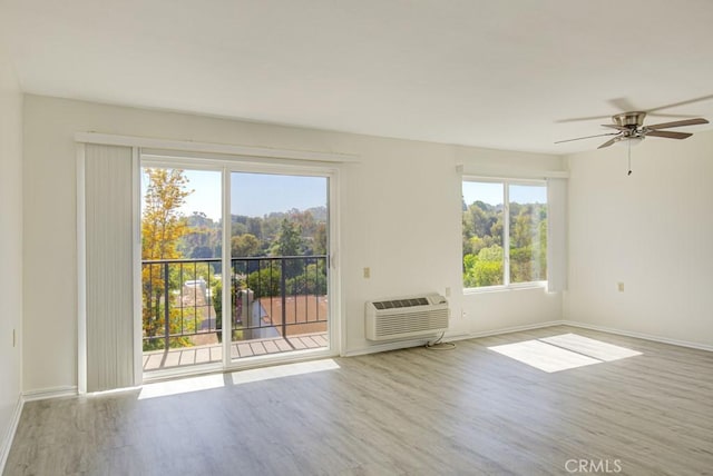 3336 Punta Alta Unit 2F, Laguna Woods, CA 92637 - empty room with a wall unit AC, wood finished floors, baseboards, and a ceiling fan