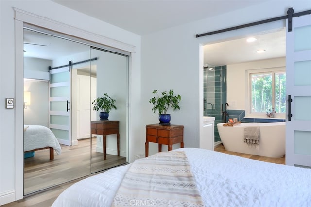 5192 Oak Rd, Mariposa, CA 95345 - bedroom featuring a barn door, a closet, and wood finished floors