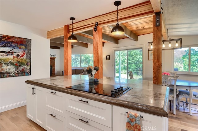 5192 Oak Rd, Mariposa, CA 95345 - kitchen with black electric stovetop, healthy amount of natural light, white cabinetry, light wood-type flooring, and beam ceiling