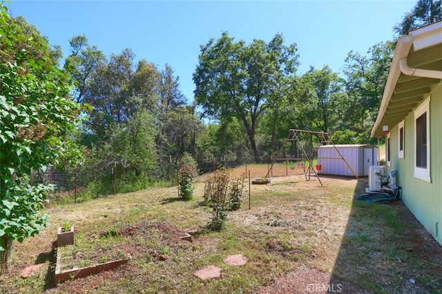 5192 Oak Rd, Mariposa, CA 95345 - view of yard featuring a storage unit, a vegetable garden, an outdoor structure, and fence