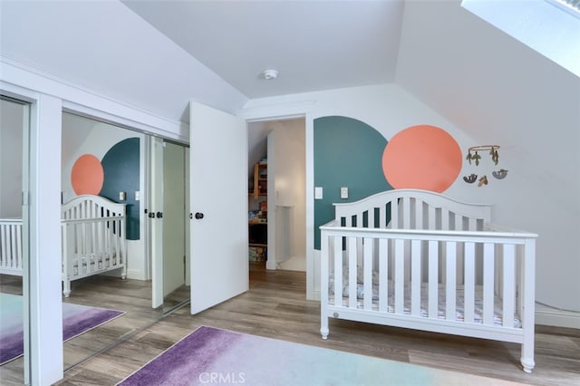 5192 Oak Rd, Mariposa, CA 95345 - bedroom featuring wood finished floors, lofted ceiling, a nursery area, a skylight, and a closet