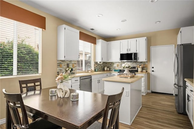 23725 Scarlet Oak Dr, Murrieta, CA 92562 - kitchen featuring stainless steel appliances, tasteful backsplash, a sink, light countertops, and wood finished floors