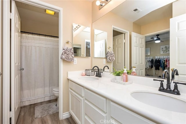 23725 Scarlet Oak Dr, Murrieta, CA 92562 - full bathroom featuring wood finished floors, toilet, double vanity, and ceiling fan