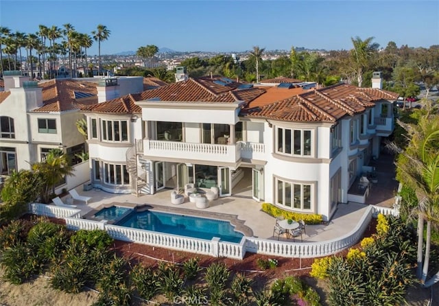 71 Ritz Cove Dr, Dana Point, CA 92629 - back of house featuring a balcony, stucco siding, a patio, an outdoor pool, and a tiled roof
