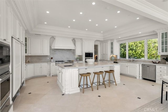 71 Ritz Cove Dr, Dana Point, CA 92629 - kitchen with appliances with stainless steel finishes, premium range hood, a center island with sink, tasteful backsplash, and recessed lighting