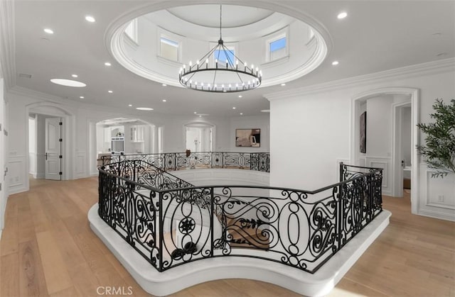 71 Ritz Cove Dr, Dana Point, CA 92629 - hall with an upstairs landing, light wood finished floors, crown molding, a chandelier, and arched walkways