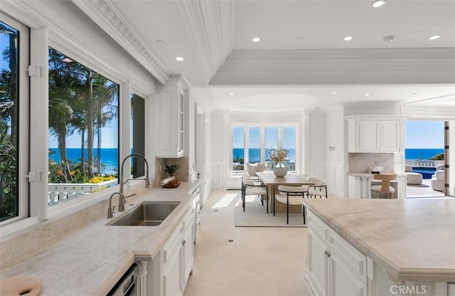 71 Ritz Cove Dr, Dana Point, CA 92629 - kitchen with a sink, backsplash, light stone counters, ornamental molding, and a water view
