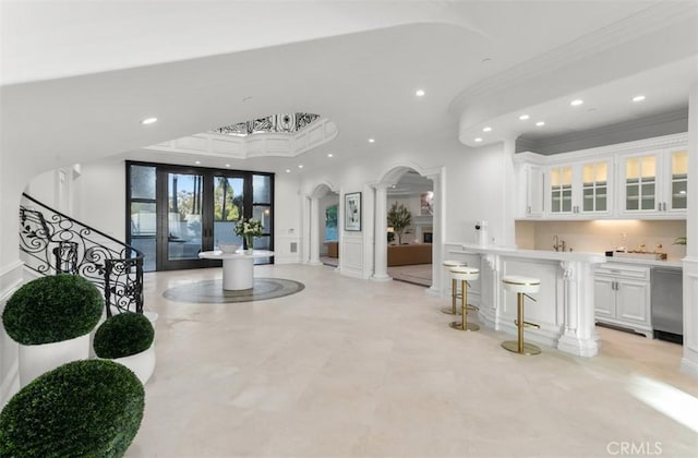 71 Ritz Cove Dr, Dana Point, CA 92629 - foyer with ornate columns, recessed lighting, bar with sink, arched walkways, and ornamental molding