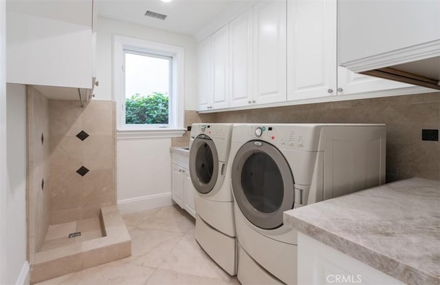 71 Ritz Cove Dr, Dana Point, CA 92629 - washroom featuring washing machine and dryer, cabinet space, light marble finish flooring, and baseboards