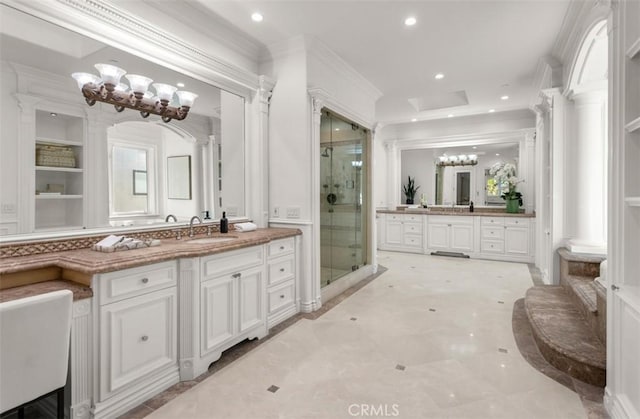 71 Ritz Cove Dr, Dana Point, CA 92629 - bathroom with a stall shower, a chandelier, recessed lighting, two vanities, and crown molding