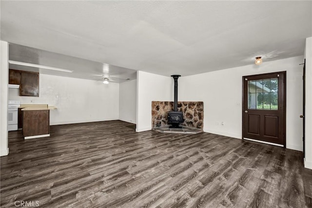 19270 Mountain S, Hidden Valley Lake, CA 95467 - unfurnished living room featuring a wood stove, dark wood-style floors, baseboards, and ceiling fan