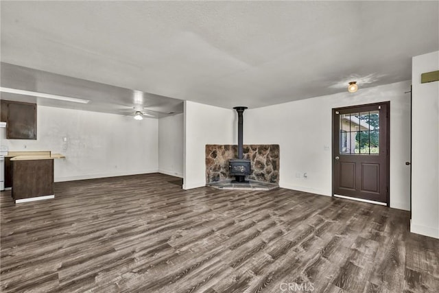19270 Mountain S, Hidden Valley Lake, CA 95467 - below grade area featuring a wood stove, dark wood-style flooring, baseboards, and a ceiling fan