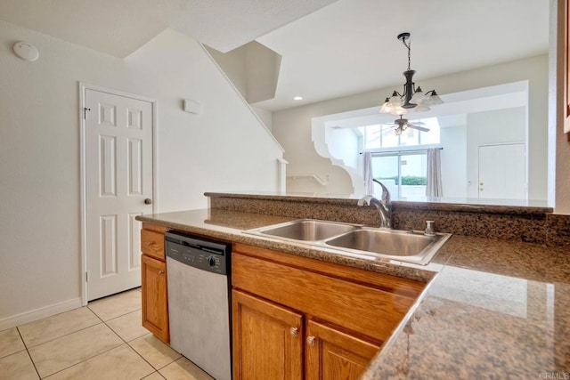 kitchen featuring stainless steel dishwasher, a sink, brown cabinets, light tile patterned floors, and decorative light fixtures