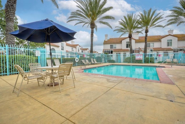 community pool with fence and a patio