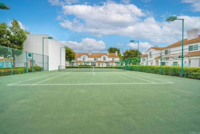 view of tennis court with fence and community basketball court