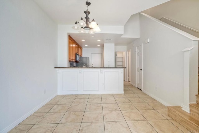 kitchen featuring dark countertops, a chandelier, hanging light fixtures, light tile patterned floors, and recessed lighting