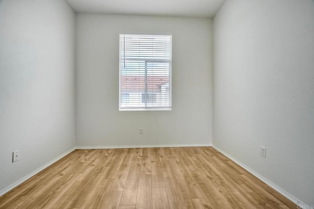 spare room with light wood-type flooring and baseboards