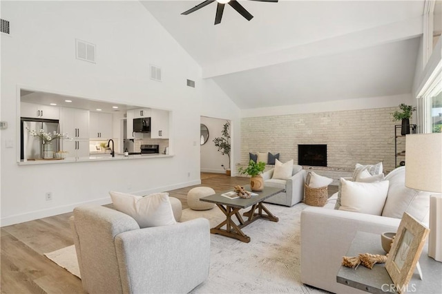3238 N Hartman St, Orange, CA 92865 - living room with brick wall, a ceiling fan, baseboards, high vaulted ceiling, and light wood-style flooring