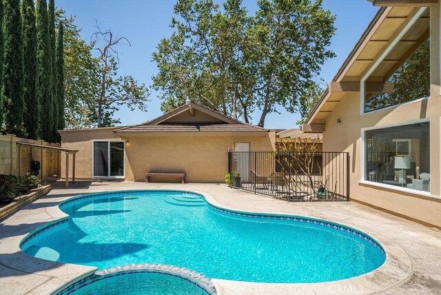 3238 N Hartman St, Orange, CA 92865 - view of swimming pool featuring a pool with connected hot tub, fence, and a patio