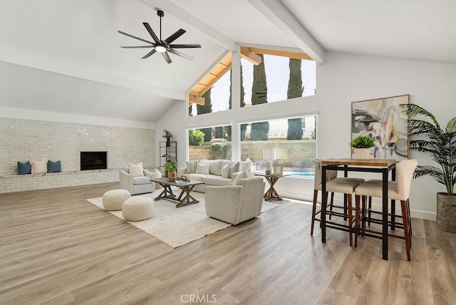 3238 N Hartman St, Orange, CA 92865 - living room featuring a ceiling fan, high vaulted ceiling, beam ceiling, wood finished floors, and brick wall