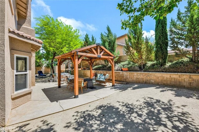 view of patio featuring a gazebo, an outdoor hangout area, and a fenced backyard