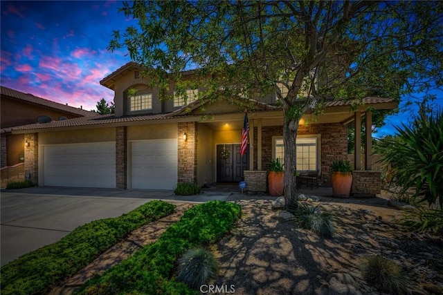 view of front of home featuring concrete driveway, a porch, stucco siding, and stone siding