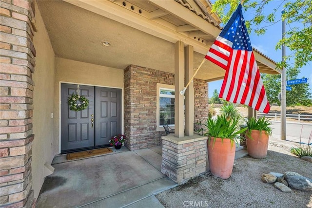 entrance to property with brick siding and stucco siding