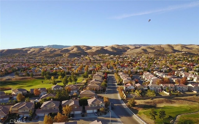 aerial view of property's location featuring mountains, nearby suburban area, and a local golf course