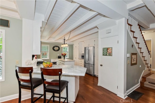 27844 Greenway Dr, Lake Arrowhead, CA 92352 - kitchen featuring high end refrigerator, a peninsula, dark wood-type flooring, white cabinetry, and beamed ceiling