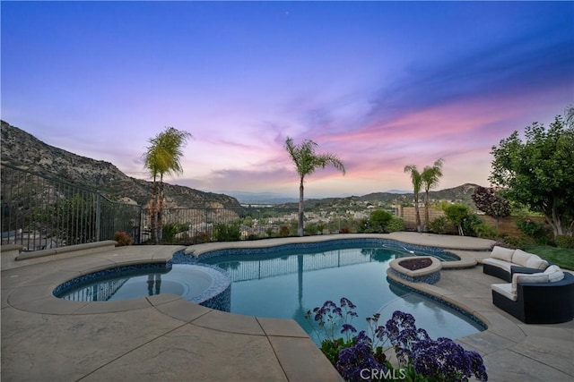 25865 Tulip Grove St, Stevenson Ranch, CA 91381 - pool at dusk with a pool with connected hot tub, a patio, a mountain view, and a fenced backyard