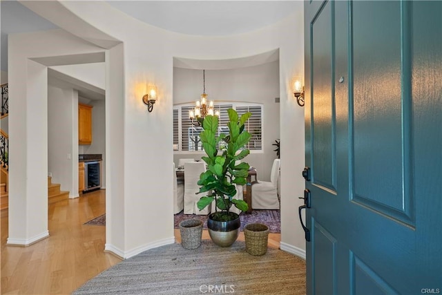 25865 Tulip Grove St, Stevenson Ranch, CA 91381 - entryway with beverage cooler, light wood-style flooring, a chandelier, and stairs
