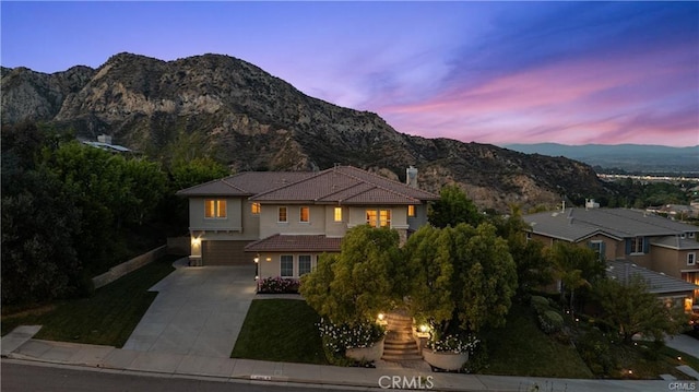 25865 Tulip Grove St, Stevenson Ranch, CA 91381 - view of front of house with concrete driveway, a garage, a mountain view, stucco siding, and a tiled roof