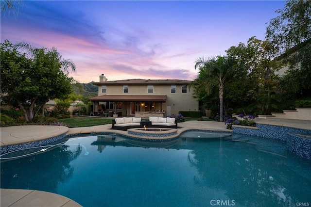 25865 Tulip Grove St, Stevenson Ranch, CA 91381 - pool at dusk with an outdoor living space with a fire pit, an outdoor pool, and a patio