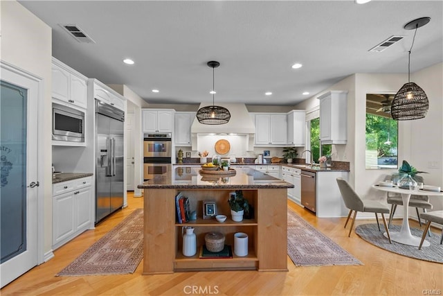 25865 Tulip Grove St, Stevenson Ranch, CA 91381 - kitchen featuring built in appliances, custom range hood, open shelves, white cabinets, and light wood-style flooring