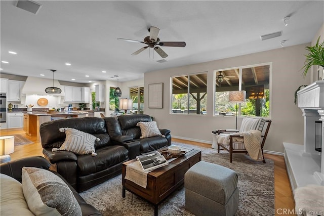 25865 Tulip Grove St, Stevenson Ranch, CA 91381 - living area featuring a ceiling fan, recessed lighting, light wood finished floors, and a fireplace with raised hearth