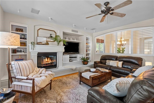 25865 Tulip Grove St, Stevenson Ranch, CA 91381 - living room featuring built in features, a ceiling fan, a glass covered fireplace, and wood finished floors
